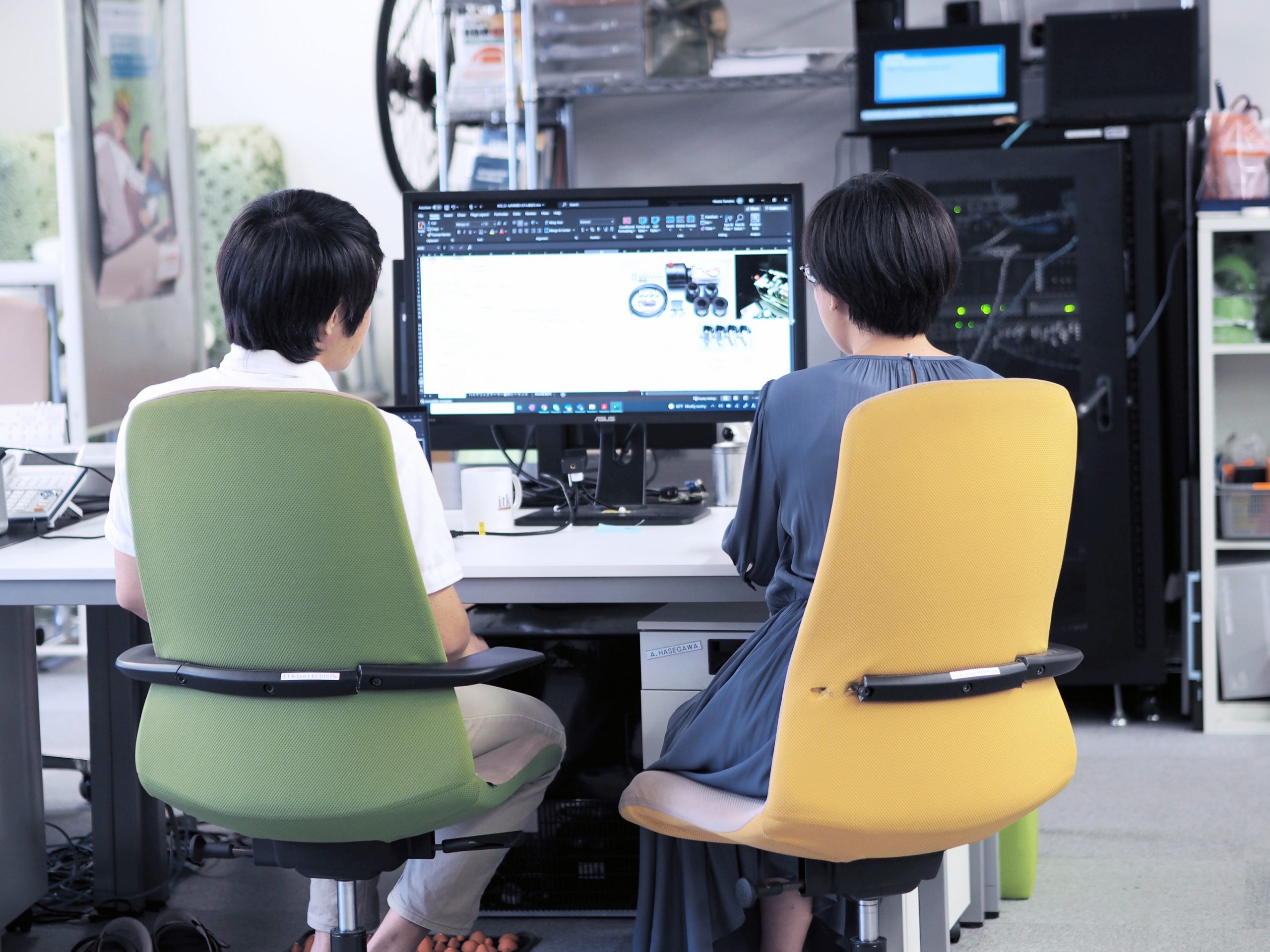 two employees sitting in front of a shred screen