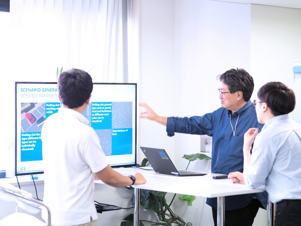 three engineers looking at a presentation on a big screen